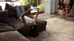 Vista frontal de uma menina caucasiana tween lendo em uma sala de estar — Fotografia de Stock