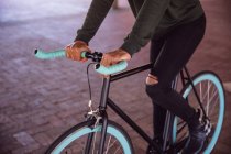 Вид сбоку: средняя часть модного на улице, езда на велосипеде — стоковое фото