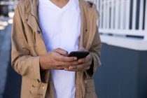 Vista frontal seção média de uma moda na rua, mensagens de texto no smartphone — Fotografia de Stock