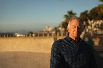 Portrait d'un homme blanc mature au bord de la mer au coucher du soleil — Photo de stock