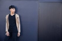 Вид збоку модна молода змішана раса транссексуал дорослий на вулиці на сірій стіні — стокове фото