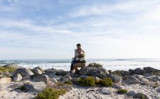 Перед очима дорослої кавказької пари, яка у сонячний день проводить вільний час, тримаючись разом на березі моря. — стокове фото