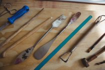 Различные металлические инструменты на деревянном столе в мастерской — стоковое фото