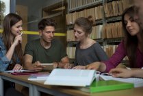 Studenti universitari che studiano alla scrivania in biblioteca — Foto stock