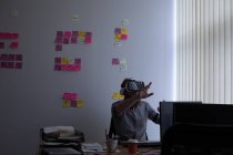 Führungskraft nutzt Virtual-Reality-Headset bei der Arbeit am Schreibtisch im Büro — Stockfoto