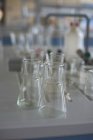 Vista de alta ángel de vasos de precipitados en el escritorio en el laboratorio - foto de stock