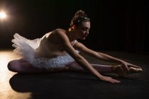 Bailarina de ballet femenina estirándose antes de bailar en el estudio - foto de stock