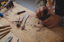 Craftsman working on clay sculpture in workshop — Stock Photo