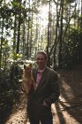 Homem maduro com seu cão de estimação na floresta — Fotografia de Stock