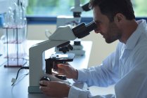University student doing experiment on microscope in laboratory at college — Stock Photo