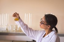 Дівчина-підліток практикує хімічний експеримент в лабораторії — стокове фото