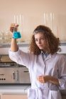 Teenage female practicing chemistry experiment in lab — Stock Photo