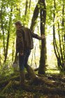 Чоловік гуляє в сільській місцевості в лісі в сонячний день — стокове фото