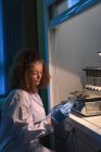 Studente universitaria donna che tiene attrezzature durante la pratica esperimento in laboratorio — Foto stock