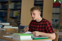Junger männlicher College-Student studiert am Schreibtisch im Klassenzimmer — Stockfoto