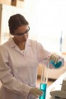 Девочка-подросток в защитных очках во время научных экспериментов в лаборатории — стоковое фото