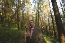 Uomo maturo con il suo cane da compagnia nella foresta — Foto stock