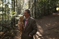 Зрілий чоловік зі своєю собакою у лісі — стокове фото
