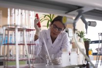Teenage female university student practicing experiment in chemistry lab — Stock Photo