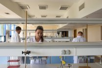 Jovens estudantes universitários que praticam experiências em laboratório — Fotografia de Stock