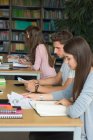Side view of college students studying at desk in classroom — Stock Photo