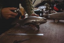 Metà sezione di artigiano modellare un pesce di metallo in officina — Foto stock
