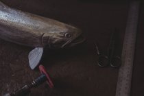 Металлическая рыба и ручной инструмент на рабочем столе в мастерской — стоковое фото