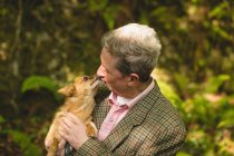 Mature man with his pet dog in forest — Stock Photo