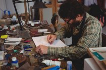 Craftsman drawing sculpture design in workshop — Stock Photo