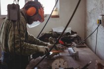 Artisan sciage métal avec outil électrique en atelier — Photo de stock