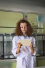Дівчина-підліток використовує планшет, стоячи в лабораторії — стокове фото