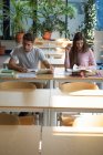 Jóvenes estudiantes universitarios que estudian en el escritorio en calssroom - foto de stock