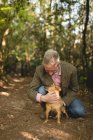 Зрелый мужчина с собакой в лесу — стоковое фото