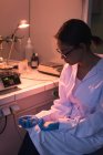 Estudante feminina segurando equipamentos enquanto pratica experiência em laboratório — Fotografia de Stock