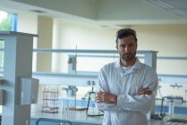 Portrait of university student standing with arms crossed in laboratory — Stock Photo