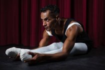 Ballerino che fa esercizio di stretching sul palco — Foto stock