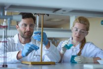 Étudiants universitaires attentifs faisant une expérience chimique en laboratoire — Photo de stock