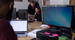 Kollegen nutzen digitales Tablet bei der Arbeit am Schreibtisch im Büro — Stockfoto