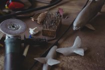 Peixe de metal e ferramenta de mão na bancada na oficina — Fotografia de Stock