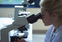 Estudante universitário fazendo experiência em microscópio em laboratório na faculdade — Fotografia de Stock