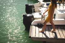 Mittelteil eines kaukasischen Mädchens im Teenageralter, das seinen Urlaub in der Sonne an der Küste genießt und auf einem Steg spaziert — Stockfoto