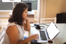 Белая женщина-блогер дома, в своей гостиной, использует ноутбук, чтобы подготовить свой онлайн-блог. Социальное дистанцирование и самоизоляция в карантинной изоляции. — стоковое фото