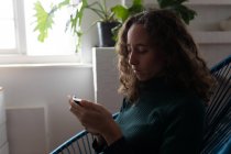 Серед тієї частини кавказької жінки, яка проводить час удома, користуючись своїм смартфоном. Стиль життя вдома ізольований, соціальна дистанція в карантині під час коронавірусу covid 19 пандемії. — стокове фото