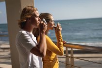Caucasian couple standing on a balcony, drinking coffee. Social distancing and self isolation in quarantine lockdown. — Stock Photo