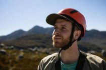 Vista frontale da vicino a uomo caucasico godendo del tempo in natura, indossando attrezzature zip fodera in una giornata di sole in montagna — Foto stock