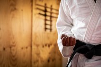 Front view mid section of judoka wearing blue judogi, warming up before a training in a gym, striking a pose, punching the air. — Stock Photo