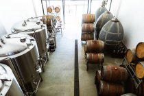 Vista de alto ângulo de uma pequena fermentação de cervejaria e compartimento de armazenamento com cubas e barris de madeira colocados ao longo das paredes. — Fotografia de Stock