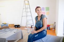Caucasian woman spending time at home self isolating and social distancing in quarantine lockdown during coronavirus covid 19 epidemic, taking a break while renovating her home, drinking coffee. — Stock Photo