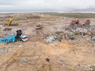 Снимок беспилотника с машинами, работающими, убирающими и доставляющими мусор, сваленный на свалку, полную мусора. Глобальная экологическая проблема утилизации отходов. — стоковое фото