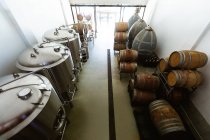Vista ad alto angolo di un piccolo birrificio vano di fermentazione e stoccaggio con vasche e botti di legno poste lungo le pareti. — Foto stock